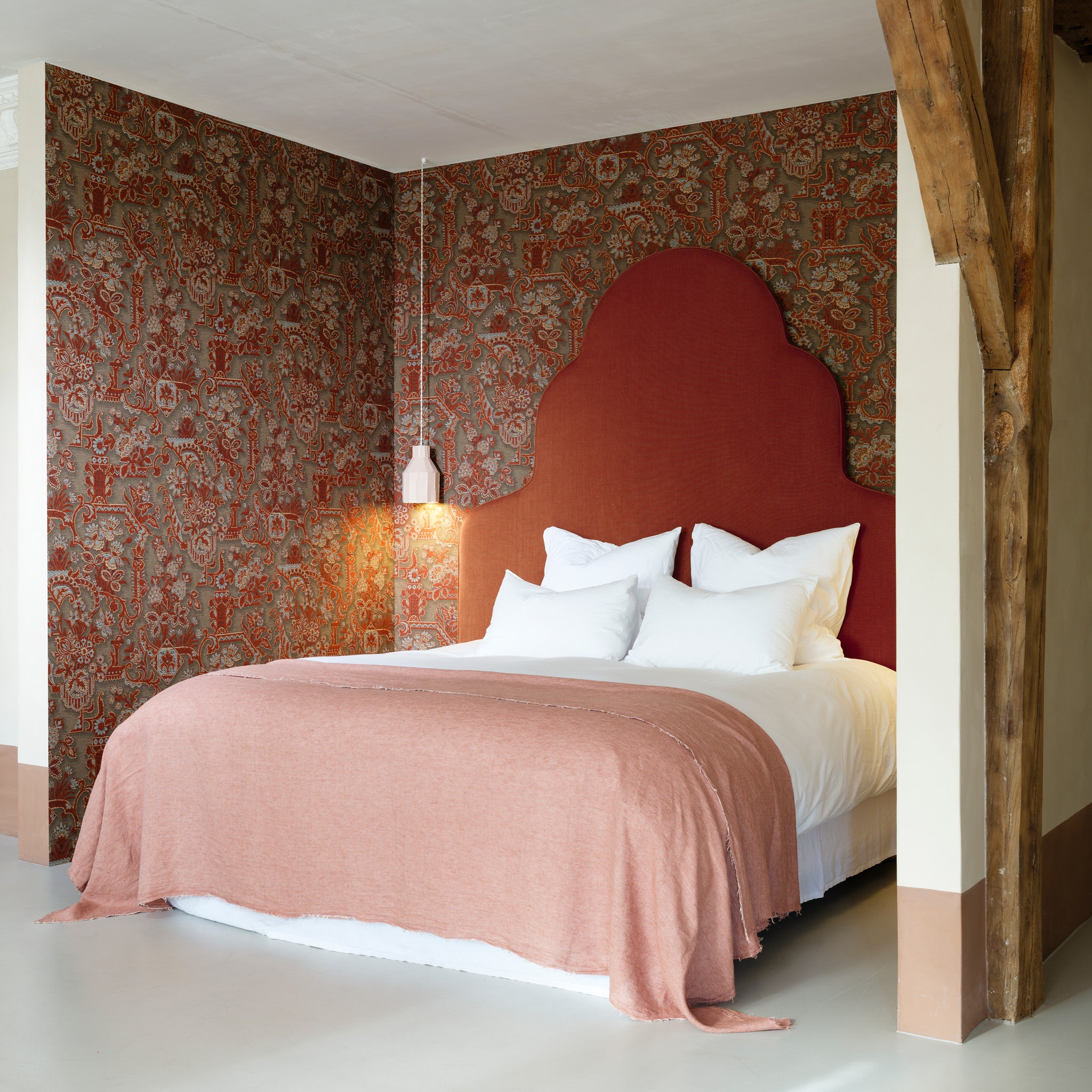 Bedroom with a red headboard and patterned wall