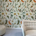 Room interior with floral and fairy wallpaper and a beige sofa.
