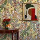 Decorative room interior with floral wallpaper, a table with flowers, and abstract art.